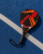 Raquette de padel LBS posée sur un court bleu