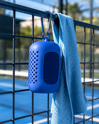 Étui de la serviette microfibre de padel LBS accroché au grillage du court